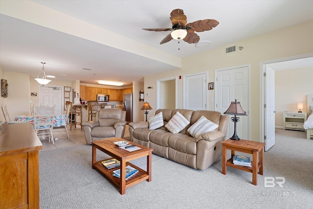 living room with light carpet and ceiling fan