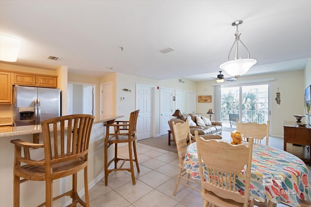 dining room with ceiling fan and light tile floors