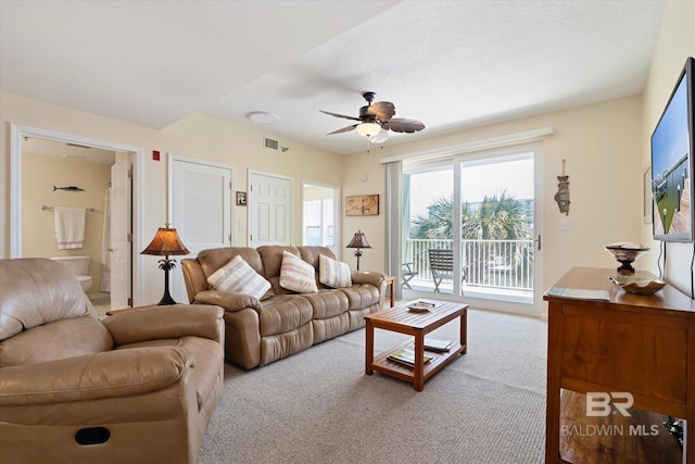 carpeted living room with ceiling fan