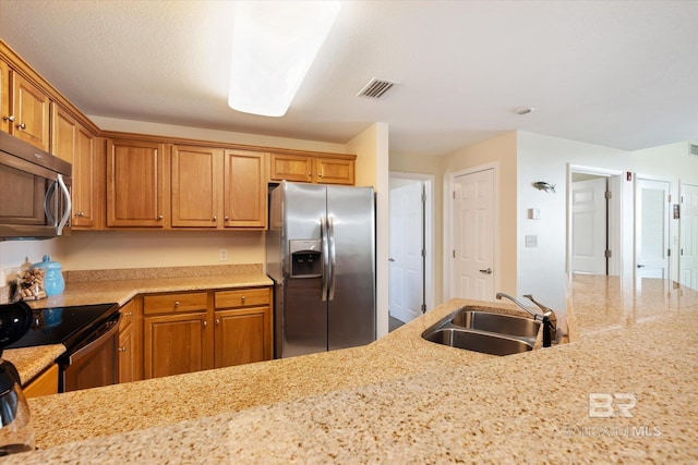 kitchen with stainless steel appliances, sink, and light stone counters