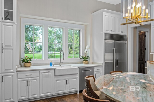 kitchen with a sink, plenty of natural light, stainless steel appliances, and white cabinets