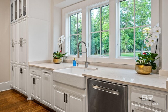 kitchen with a sink, light stone countertops, white cabinetry, and dishwasher