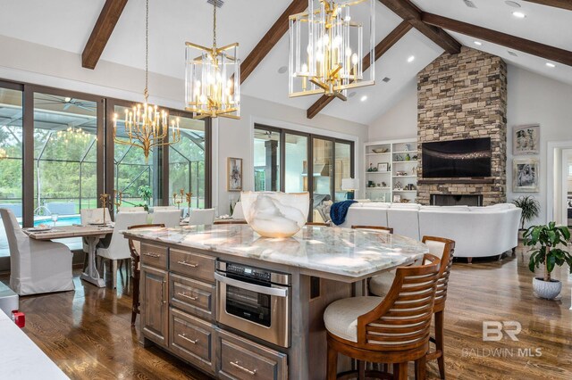 kitchen featuring oven, a fireplace, a chandelier, dark wood finished floors, and beamed ceiling