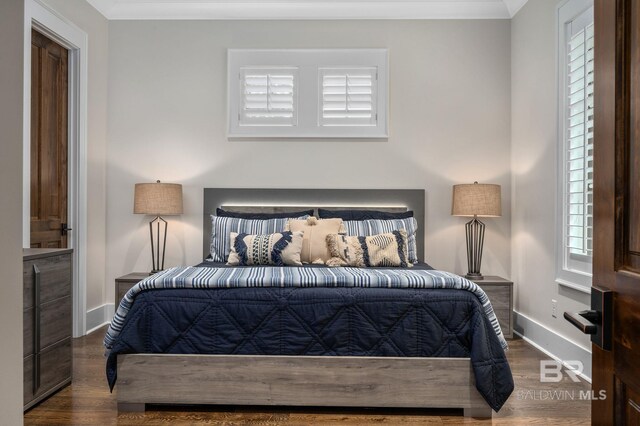 bedroom with baseboards, crown molding, and wood finished floors