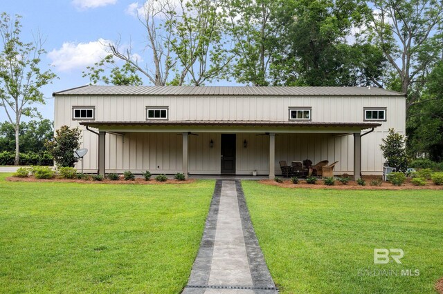 view of front of property featuring ceiling fan, a front yard, and metal roof