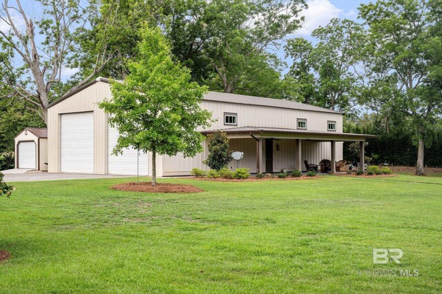 view of front of house with an outdoor structure, a front lawn, and a detached garage