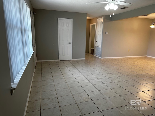 unfurnished room featuring light tile patterned floors and ceiling fan