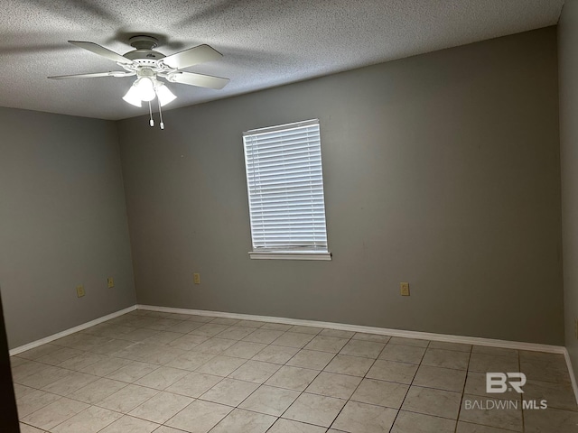 empty room with light tile patterned floors, a textured ceiling, and ceiling fan