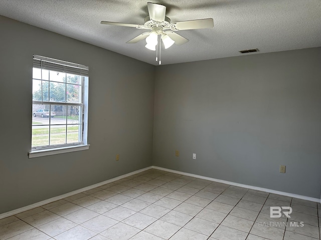 tiled spare room featuring a textured ceiling and ceiling fan