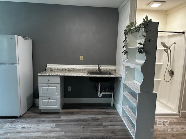 bathroom featuring wood-type flooring, sink, and walk in shower