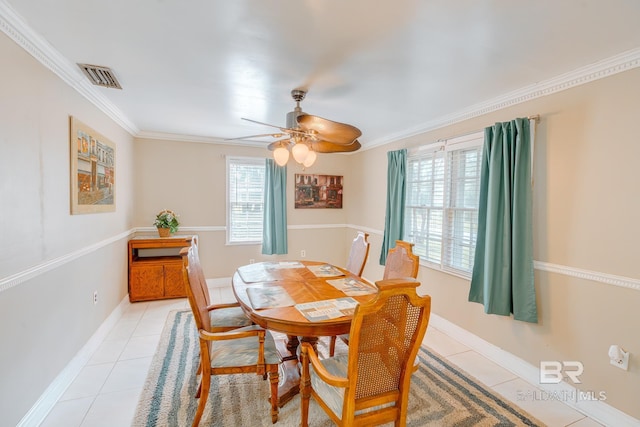 dining space with light tile patterned floors, a ceiling fan, crown molding, visible vents, and baseboards
