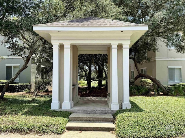 200 Peninsula Blvd Unit A202, Gulf Shores, AL 36542 - doorway to property with a shingled roof, a porch, and a yard