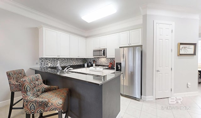 200 Peninsula Blvd Unit A202, Gulf Shores, AL 36542 - kitchen featuring appliances with stainless steel finishes, dark countertops, backsplash, ornamental molding, and a peninsula