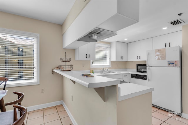 517 E Beach Blvd Unit 5D, Gulf Shores, AL 36542 - kitchen featuring freestanding refrigerator, a peninsula, black microwave, light tile patterned flooring, and light countertops