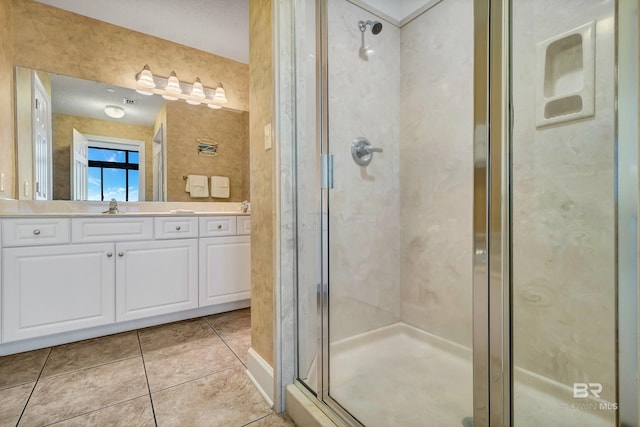 bathroom featuring a shower with shower door, tile flooring, and vanity