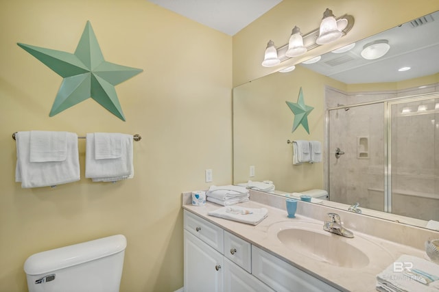 bathroom featuring a shower with door, toilet, and large vanity