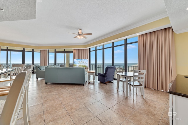 tiled living room with ornamental molding, plenty of natural light, a water view, and a textured ceiling