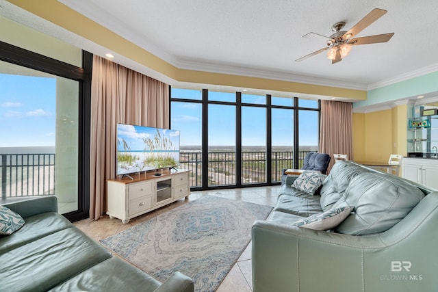 living room with ceiling fan, light tile floors, a textured ceiling, ornamental molding, and floor to ceiling windows