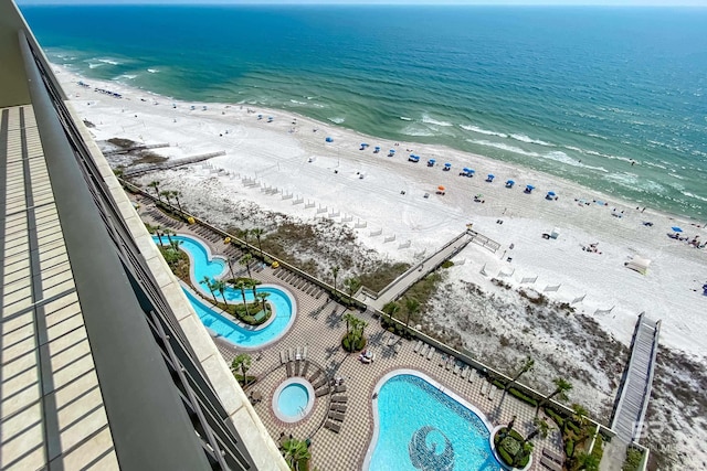 birds eye view of property featuring a beach view and a water view