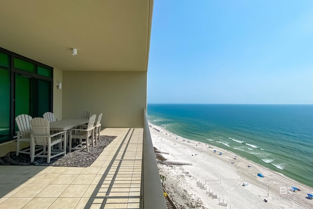 balcony with a water view and a view of the beach