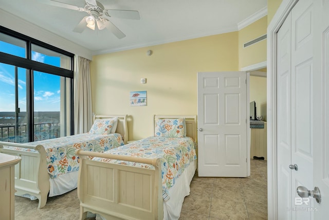 bedroom with a closet, ceiling fan, light tile flooring, and crown molding