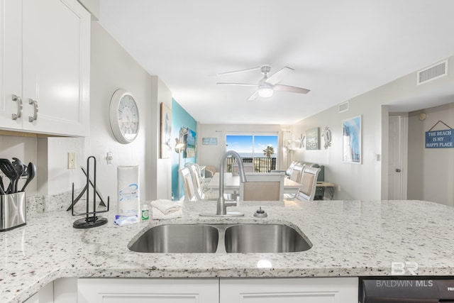 kitchen with white cabinets, visible vents, a sink, and ceiling fan
