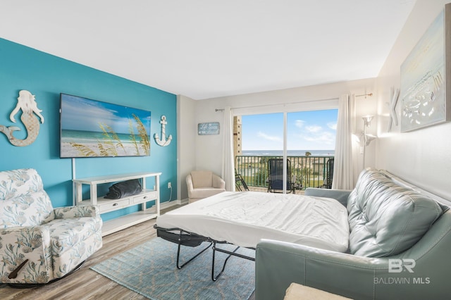 bedroom featuring access to exterior and wood finished floors