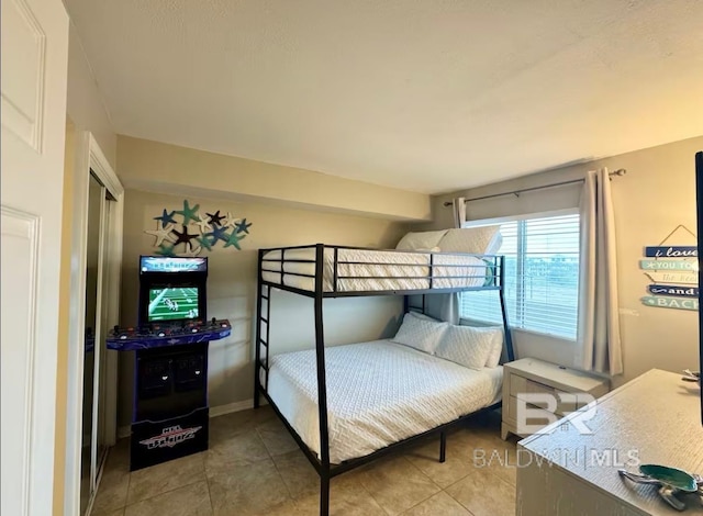 bedroom with tile patterned floors and baseboards