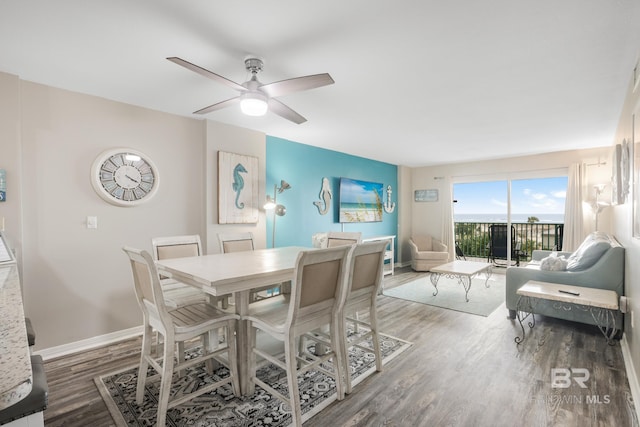 dining room featuring baseboards, a ceiling fan, and wood finished floors