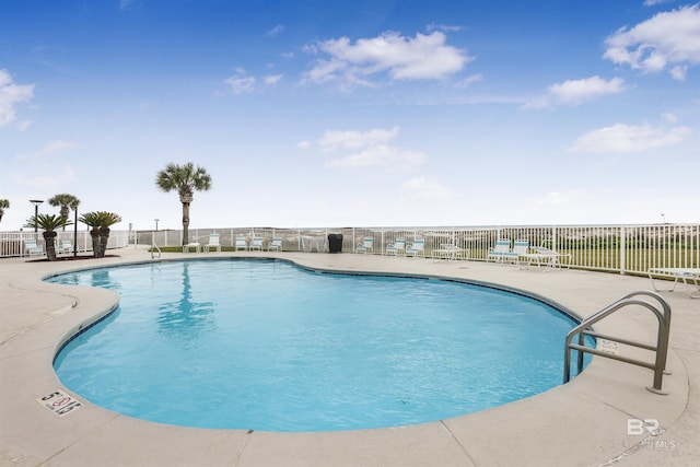 community pool with a patio and fence