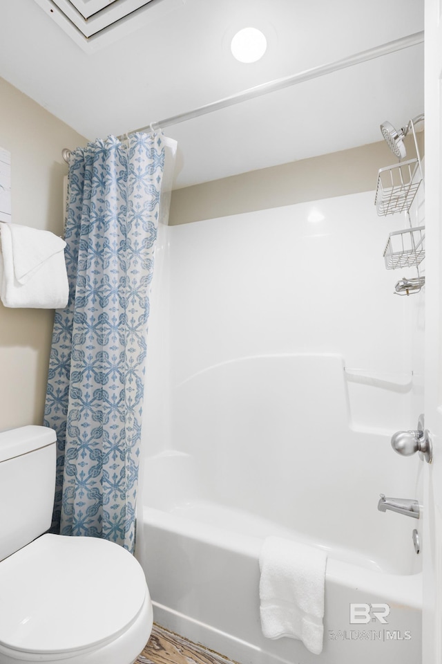 bathroom featuring toilet, shower / bath combo, and wood finished floors