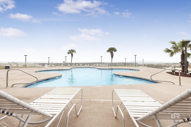 community pool featuring a patio area and fence