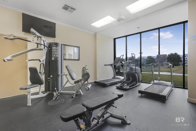 exercise room featuring ornamental molding, visible vents, and baseboards