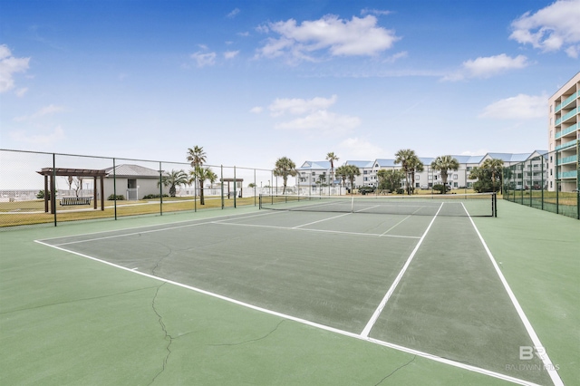view of sport court with a residential view and fence