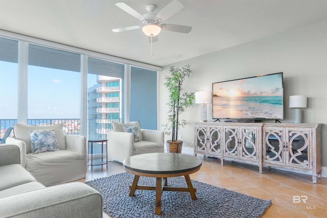 living room featuring plenty of natural light, a wall of windows, ceiling fan, and light tile floors