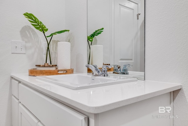 room details with vanity and a textured wall