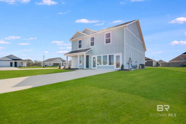 view of front of home featuring central AC unit, board and batten siding, driveway, and a front lawn