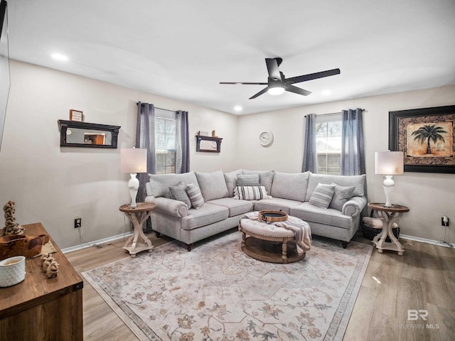 living room featuring wood-type flooring and ceiling fan