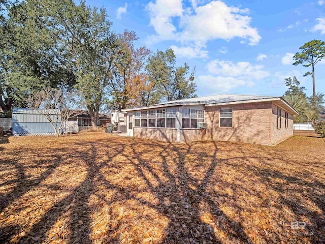 rear view of property featuring a sunroom