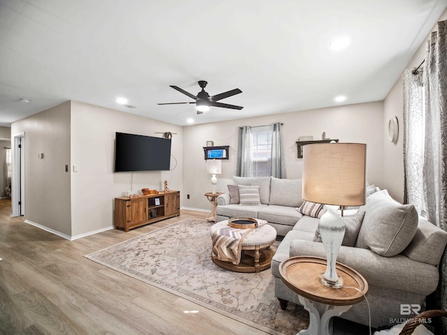 living room with hardwood / wood-style flooring and ceiling fan