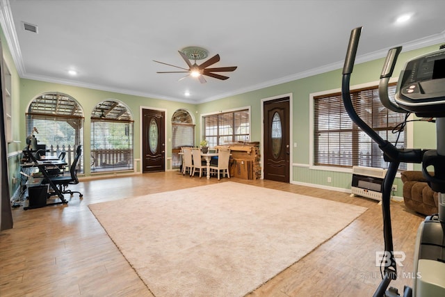 exercise room featuring ornamental molding, light hardwood / wood-style floors, and ceiling fan