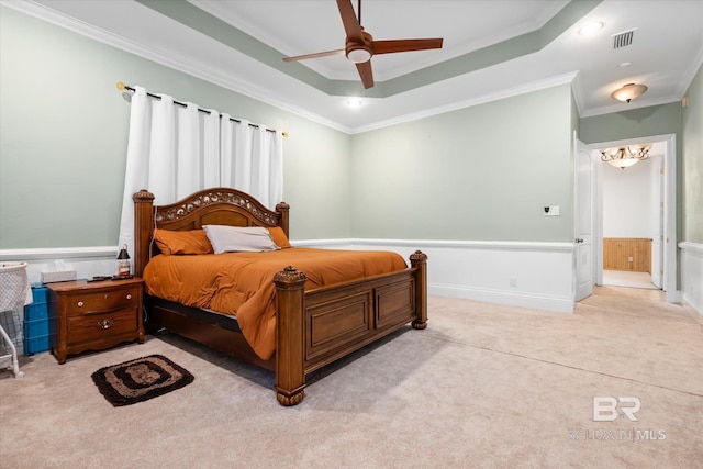 bedroom featuring crown molding, a tray ceiling, ceiling fan, and ensuite bathroom