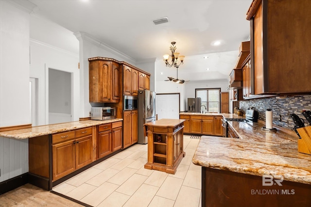 kitchen with light stone counters, a center island, appliances with stainless steel finishes, and kitchen peninsula