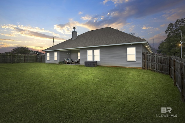 back house at dusk with a yard