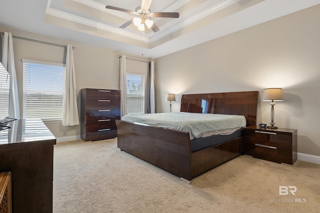 carpeted bedroom featuring a tray ceiling, ceiling fan, and crown molding