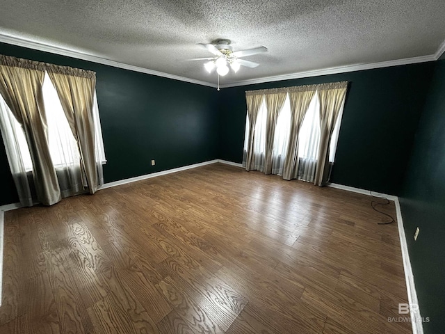 spare room with a ceiling fan, a textured ceiling, wood finished floors, ornamental molding, and baseboards