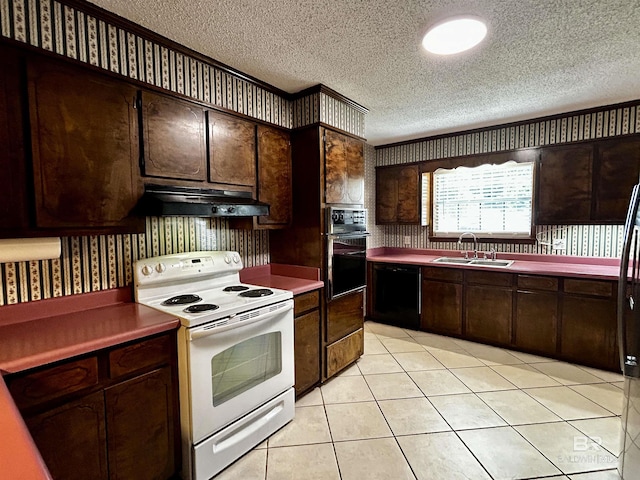 kitchen featuring black appliances, wallpapered walls, a textured ceiling, a sink, and under cabinet range hood