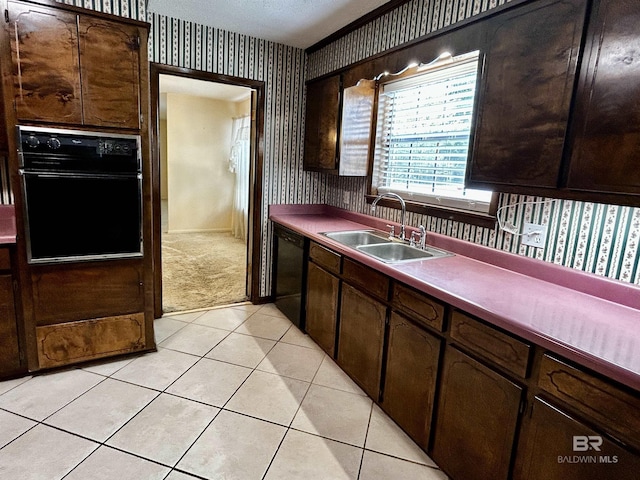 kitchen with wallpapered walls, black appliances, a sink, light tile patterned floors, and light carpet
