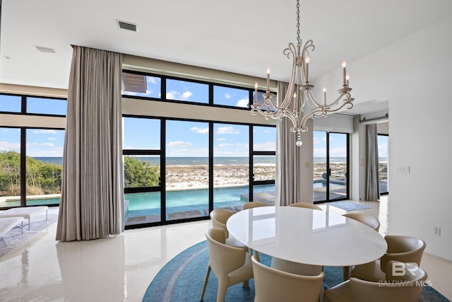7276 Kiva Way, Gulf Shores, AL 36542 - dining area with a chandelier, healthy amount of natural light, a water view, and a towering ceiling