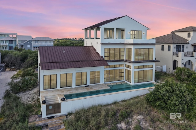 7276 Kiva Way, Gulf Shores, AL 36542 - back of property featuring stucco siding, a balcony, and metal roof